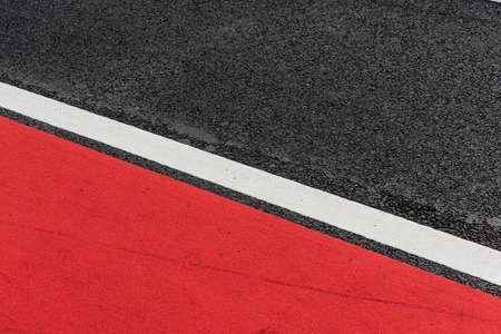 Asphalt decorated with a white line and a red field.の写真素材