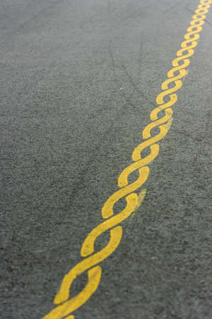 Yellow striped pattern painted on a road.の写真素材