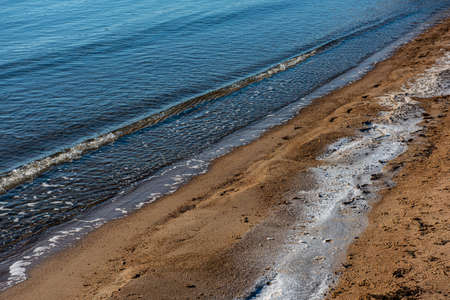 Sand beach in winter. Ice on the shore.の写真素材