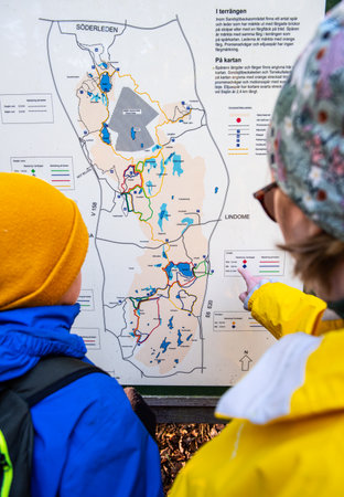 MÃ¶lndal, Sweden - October 17 2020: Two persons looking at a map of SisjÃ¶n and SandsjÃ¶backa.