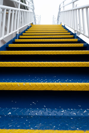 Metal stairs in blue and yellow on a ship