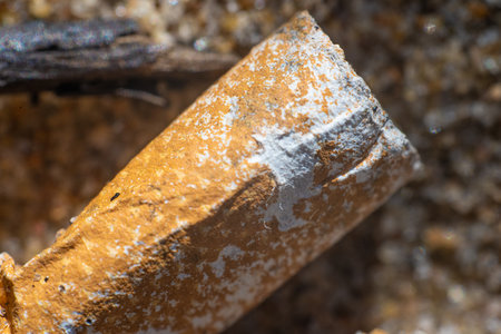 Old cigarette butt thrown away in the sand on a beachの写真素材