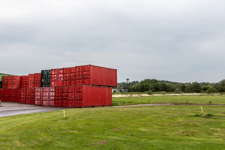 Gothenburg, Sweden - september 24 2022: Red shipping containers stacked bu a green fieldのeditorial素材