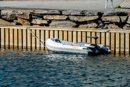 KungÃ¤lv, Sweden - July 15 2022: Small dinghy with an electric motor moored by a pierのeditorial素材