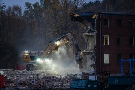 Gothenburg, Sweden - October 25 2022: Large excavator demolishing a brick office buildingのeditorial素材