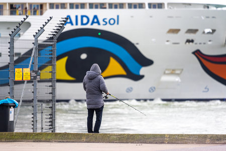 Gothenburg, Sweden - October 29 2022: Large cruise ship AIDAsol departing while man fish from the dockのeditorial素材