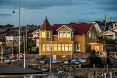 Gothenburg, Sweden - september 18 2022: sunset ligt on a yellow large wooden house by a harborのeditorial素材