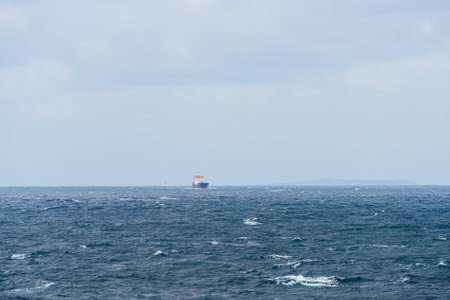Freight ship passing through choppy wavesの写真素材