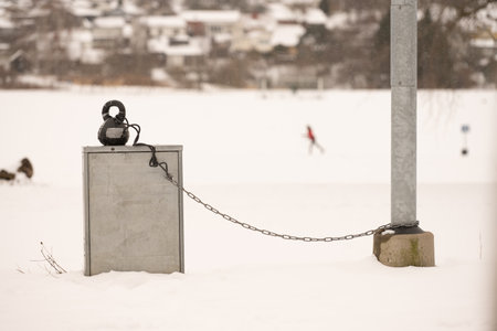 Kettlebell linked by chain to a light pole at in a snowy parkの写真素材