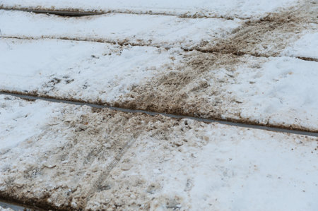 Bicycle tracks in snow over tram tracks