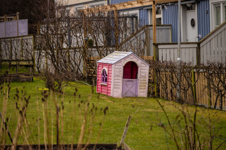 Pink and purple plastic children play house in a gardenの写真素材