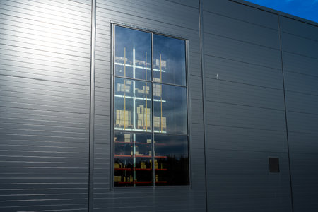 Boxes and pallets visible through a window at a large warehouse