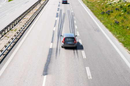 Car driving fast down a highway with log tire skid marksの写真素材