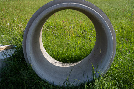 A concrete manhole in a grass fieldの写真素材
