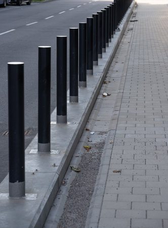 Metal poles protecting a building and sidewalkの写真素材