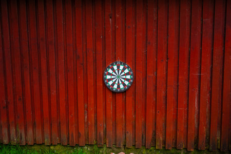 Dart board hanging on a red wooden wallの写真素材