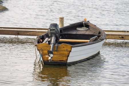 Old wooden small boat with a small outboard engineの写真素材
