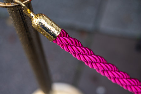 Bright pink rope on a golden poleの写真素材