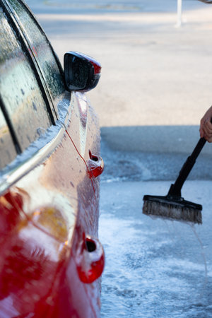 Side of a red car at a car washの写真素材
