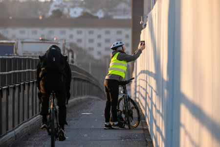 Gothenburg, Sweden - March 05 2024: Bicyclist photographing the view from a bridgeのeditorial素材