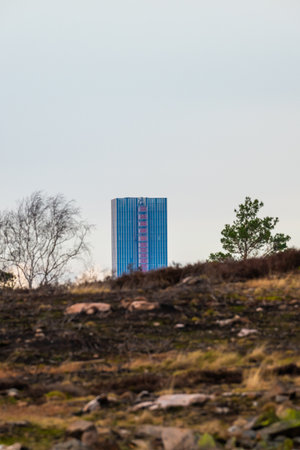Gothenburg, Sweden - February 25 2024: Tall skyscraper visible behind a hillのeditorial素材