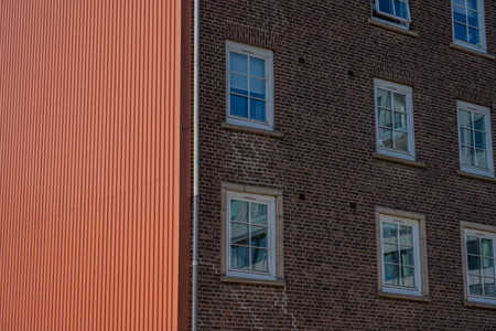 Red metal plate wall by a brick building
