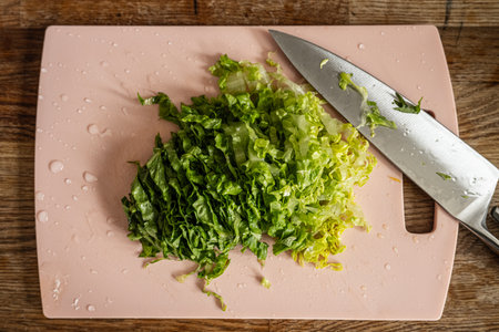 Freshly cut green salad on pink cutting board
