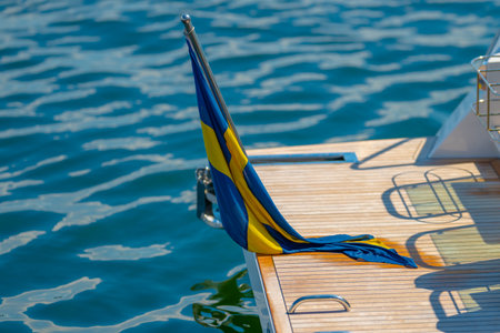 Wet swedish flag on the bathing platform of a boat