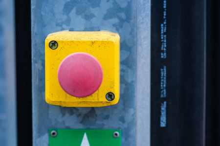 Red faded stop butten for an electric gate at a building siteの写真素材
