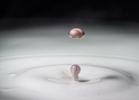 Drops of coloured liquid in milkの写真素材