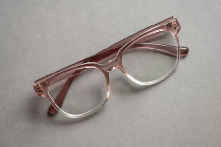 Pink glasses on grey background
