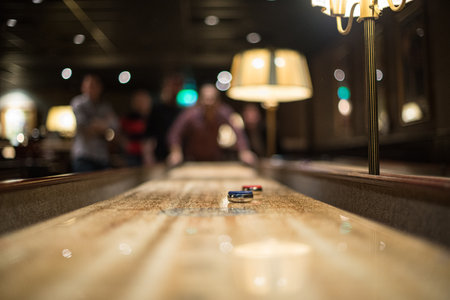 Shuffleboard game in dimly lit bar