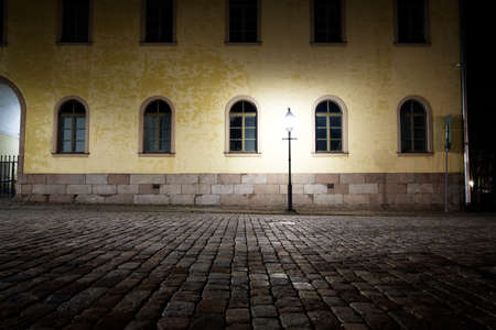 Empty street at night in the light of old-fashioned street lamp.の写真素材