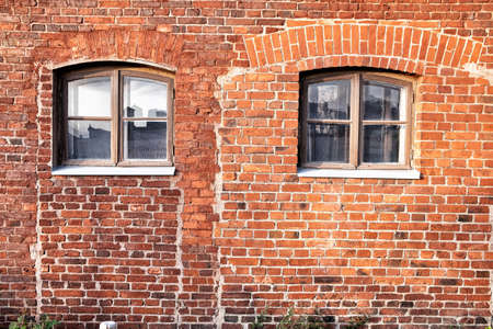Old red brick wall with windows.の写真素材