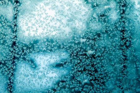 Closeup of frozen ice crystals on window glass in winter.の写真素材