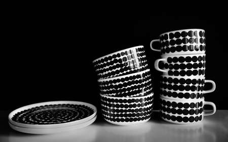 A set of dishes on black background. Mugs, bowls and plates on white table.の写真素材