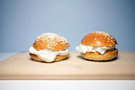 A traditional Scandinavian shrovetide buns with whipped cream on white table. Shrovetide buns are classic delicacies for Shorevetide Sunday and Tuesday.の写真素材