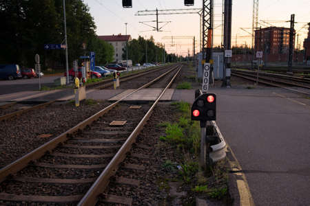 Traffic light shows red signal on railway in the nightfall.の写真素材