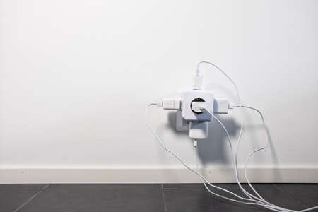 Modern power socket with four cables plugged to it.の写真素材