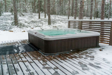 Modern outdoor bathtub on a wooden deck in the cold winter day, Salo, Finland.の写真素材
