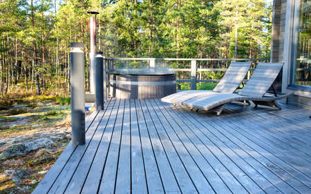 Modern big barrel outdoor hot tub in the middle of forest. The hot tub's soothing warm water relaxes muscles and eases tensions, so your worries can simply melt away.の写真素材