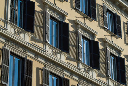 Window patterns: Rows of windows on an ornamented facade of building with shadows