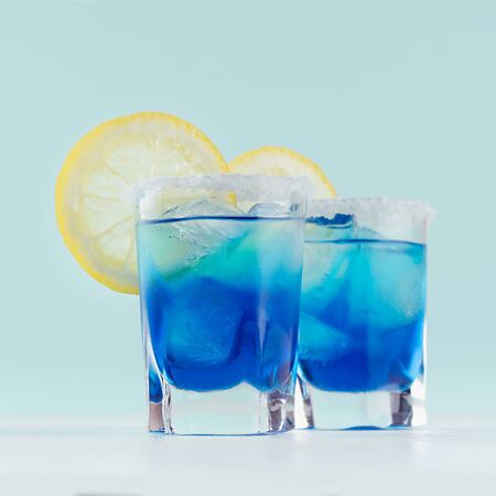 Youth fresh alcohol blue Hawaii cocktail with liquor curacao, ice cube, salt rim, lemon slice on...