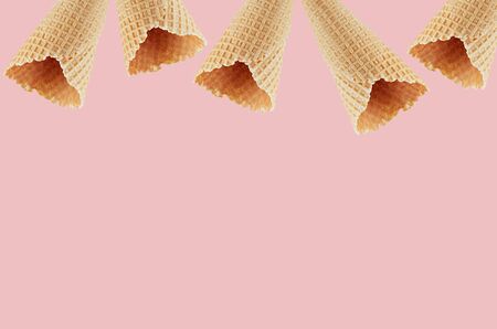 Empty waffle ice cream cones as decorative frame on pink background, mock up for advertising, design, menu.の写真素材
