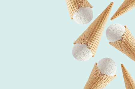 White creamy ice cream in waffle cones as decorative border on light  green background, mock up, copy space.の写真素材