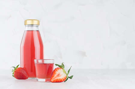 Fresh pink strawberry juice in glass bottle template with  glass, fruit slices on wood table and...