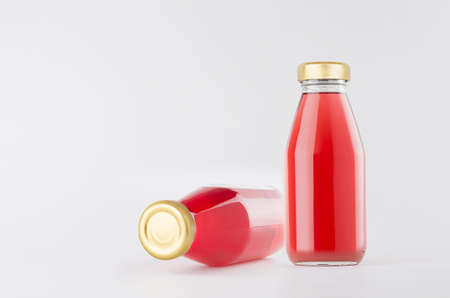 Pink strawberry juices in glass bottles with gold empty cap for label mock up on white background with copy space, template for packaging, advertising, design product, branding.の写真素材