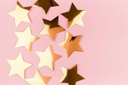 New Year festive abstract background with golden sparkle stars on pastel pink background, flat lay, border.の写真素材