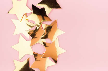 Modern festive background with golden shimmer stars on soft light pink background, copy space,...