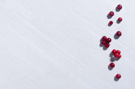 Light white wood board with red berries with copy space, top view, as abstract simple autumn background.の写真素材